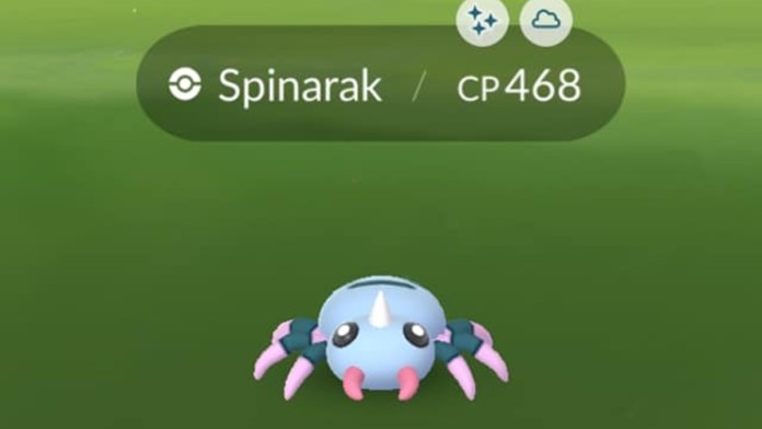 A shiny Spinarak standing on the grass in Pokemon Go.